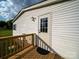 Back porch of a home showing the vinyl siding, an exterior door, and wooden porch railings at 317 Berry Trl, Wadesboro, NC 28170