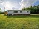 Spacious home with a large green lawn and a wooden deck, perfect for outdoor living at 317 Berry Trl, Wadesboro, NC 28170