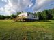 Spacious home with a large green lawn and a wooden deck with stairs, perfect for outdoor living at 317 Berry Trl, Wadesboro, NC 28170
