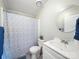 Bright bathroom featuring a round mirror, white vanity, and a decorative blue and white shower curtain at 317 Berry Trl, Wadesboro, NC 28170