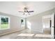 Sunlit bedroom with two windows offering landscape views, a modern ceiling fan, and neutral wall colors at 317 Berry Trl, Wadesboro, NC 28170