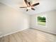 A cozy bedroom with vinyl flooring, a ceiling fan, and a window with a view of the green outdoors at 317 Berry Trl, Wadesboro, NC 28170