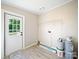 Clean laundry room with exterior door, wire shelving, laminate floors, and neutral wall colors at 317 Berry Trl, Wadesboro, NC 28170