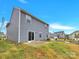 View of backyard featuring vinyl siding, sliding glass doors to the patio, and green grass under a blue sky at 3212 Coast Oak Rd, Charlotte, NC 28214