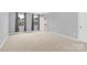 Neutral bedroom with carpeted floor, three large windows, and grey walls at 3212 Coast Oak Rd, Charlotte, NC 28214