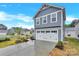 View of the two-car garage and driveway of this two-story home with gray siding and white trim at 3212 Coast Oak Rd, Charlotte, NC 28214