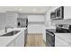 Bright, modern kitchen with white cabinets, stainless steel appliances, quartz countertops and hardwood floors at 3212 Coast Oak Rd, Charlotte, NC 28214