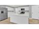 Bright, modern kitchen with white cabinets, stainless steel appliances, quartz countertops and hardwood floors at 3212 Coast Oak Rd, Charlotte, NC 28214