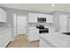 Bright, modern kitchen with white cabinets, stainless steel appliances, quartz countertops and hardwood floors at 3212 Coast Oak Rd, Charlotte, NC 28214