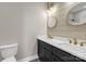 Bathroom with double sink vanity, white countertop, black cabinetry and gold hardware and two round mirrors at 32507 Buchanan Ln, Albemarle, NC 28001
