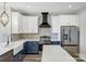 Stylish kitchen featuring white cabinets, stainless steel appliances, and a sleek black range hood at 32507 Buchanan Ln, Albemarle, NC 28001