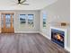 Bright living room featuring a fireplace, wood floors, and natural light from multiple windows at 32507 Buchanan Ln, Albemarle, NC 28001