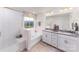 Bright bathroom showcasing a soaking tub, double vanity, and ample natural light from a large window at 4210 Steel Way, Sherrills Ford, NC 28673