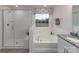 Elegant bathroom with a walk-in shower, soaking tub, and stylish fixtures with a view to the backyard at 4210 Steel Way, Sherrills Ford, NC 28673