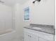 Full bathroom featuring tile floors, granite vanity, window, and tub at 4648 Simpson Rd, Edgemoor, SC 29712