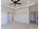 Large carpeted bedroom boasts a ceiling fan, tray ceiling and access to ensuites at 4648 Simpson Rd, Edgemoor, SC 29712