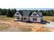 Charming new construction home featuring a welcoming porch, sleek black shutters, and a fresh concrete driveway at 4648 Simpson Rd, Edgemoor, SC 29712