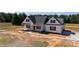 A charming new construction home featuring a welcoming front porch, sleek black shutters, and an attached garage at 4648 Simpson Rd, Edgemoor, SC 29712
