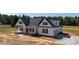 New construction home with a welcoming porch, black shutters, and attached garage is set on a large lot at 4648 Simpson Rd, Edgemoor, SC 29712