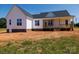 Backyard view of home with a covered porch, wooden railing, and manicured landscaping at 4648 Simpson Rd, Edgemoor, SC 29712