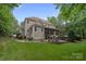 Beautiful home exterior showcasing the backyard patio and landscaped yard surrounded by lush trees at 4877 River Hills Dr, Denver, NC 28037