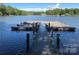 Image of a wooden dock with benches leading out onto a calm lake under a blue sky at 4877 River Hills Dr, Denver, NC 28037
