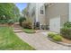 The exterior shows the stone staircase, lush plants, and a cream colored shed in the backyard at 4877 River Hills Dr, Denver, NC 28037