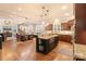 Open-concept kitchen with a large island, dark wood cabinets, and hardwood floors at 4877 River Hills Dr, Denver, NC 28037