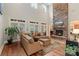 Spacious living room with a soaring stone fireplace, plenty of seating, and lots of natural light at 4877 River Hills Dr, Denver, NC 28037