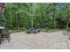 Stone patio with outdoor seating area surrounded by lush green trees at 4877 River Hills Dr, Denver, NC 28037