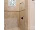 Tiled walk-in shower with bronze hardware and a built-in shower niche and seat at 4877 River Hills Dr, Denver, NC 28037