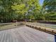 Back deck with a built-in bench offers a relaxing outdoor space overlooking a tree-filled backyard at 4901 Pine Oaks Dr, Monroe, NC 28112