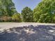 Long gravel driveway leading to the property, surrounded by lush trees and landscaping at 4901 Pine Oaks Dr, Monroe, NC 28112