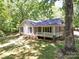 Charming home with a covered front porch, complemented by a well-manicured lawn and mature trees at 4901 Pine Oaks Dr, Monroe, NC 28112