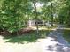 Secluded home nestled among mature trees, offering privacy and tranquility with a winding driveway at 4901 Pine Oaks Dr, Monroe, NC 28112