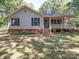 Charming single-story home featuring a covered porch, landscaped front yard, and inviting curb appeal at 4901 Pine Oaks Dr, Monroe, NC 28112