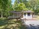 Charming home with a welcoming covered front porch surrounded by lush greenery at 4901 Pine Oaks Dr, Monroe, NC 28112