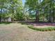 Spacious front yard featuring green grass and mature trees providing ample shade and curb appeal at 4901 Pine Oaks Dr, Monroe, NC 28112