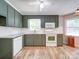 Bright kitchen with green cabinets, modern appliances, white subway tile backsplash, and wood-look flooring at 4901 Pine Oaks Dr, Monroe, NC 28112