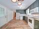 Functional kitchen features green cabinets, white appliances, and wood-look flooring with an adjacent eating area at 4901 Pine Oaks Dr, Monroe, NC 28112