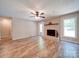 Bright living room featuring a ceiling fan, light brick fireplace, hardwood floors, and natural light at 4901 Pine Oaks Dr, Monroe, NC 28112