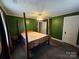 Bedroom featuring green walls, a four-poster bed, and a window with natural light at 5501 Barrier Rd, Concord, NC 28025