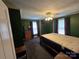 Bedroom featuring green walls, a four-poster bed, dresser, two windows with natural light at 5501 Barrier Rd, Concord, NC 28025