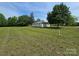 Quaint single-story home featuring a metal roof and a sprawling, well-maintained lawn with mature trees at 5501 Barrier Rd, Concord, NC 28025