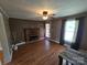 Bright living room with hardwood floors, brick fireplace, and natural light streaming through the windows at 5501 Barrier Rd, Concord, NC 28025