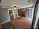 Cozy living room with hardwood floors, brick fireplace, and a view into the kitchen at 5501 Barrier Rd, Concord, NC 28025
