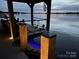 Waterfront dock featuring a covered boat slip, outdoor seating, and steps leading to the water at 578 Stonemarker Rd, Mooresville, NC 28117