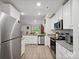 Modern kitchen featuring stainless steel appliances, granite countertops, and white cabinetry at 584 Lamorak Pl, Richburg, SC 29729