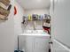 Well-organized laundry room with washer, dryer, and plenty of storage shelves at 584 Lamorak Pl, Richburg, SC 29729