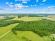 A captivating aerial view highlighting the expansive acreage with a mix of open fields and wooded areas at 5903 Wm Griffin Rd, Monroe, NC 28112